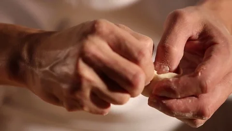 A chef is shaping the dough with meat inside to make dumplings. Stock Footage 70240522