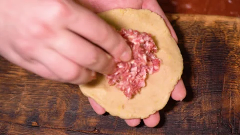 A chef is shaping the dough with meat inside to make dumplings. Stock Footage 252603327