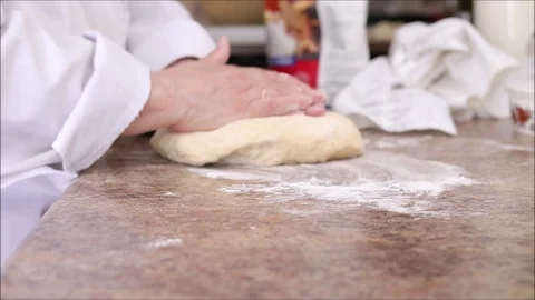 Chef shaping flat fresh bread dough into a loaf shape on a kitchen counter. Stock Footage 121276158