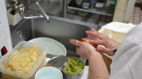 Chef shaping stuffed sushi pockets by hand in a professional kitchen setting Stock Photos