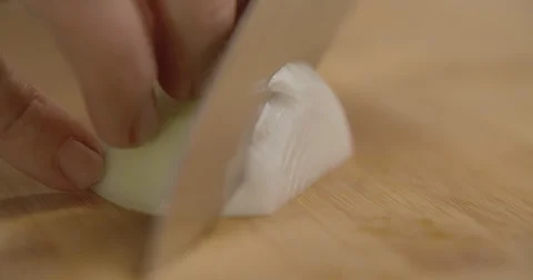 Chef with sharp knife cuts half white onion on wooden board. Slow motion 4K Stock Footage 114352749
