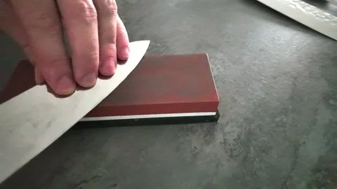 Chef sharpening kitchen knives on whetstone in kitchen 스톡 동영상 342983643