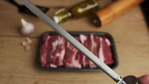 Chef sharpening a knife before cutting meat Stock Footage 238904470