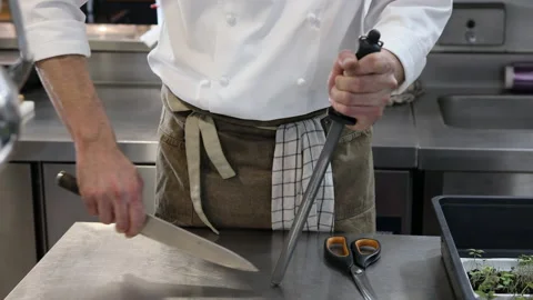 Chef sharpening a knife in a professional kitchen of a restaurant. Stock Footage 221093814