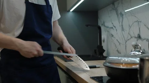 Chef sharpening knives in a modern kitchen setting Stock Footage 310518644