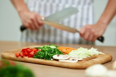 Chef sharpening knives preparing fresh vegetables for healthy cooking Stock Photos