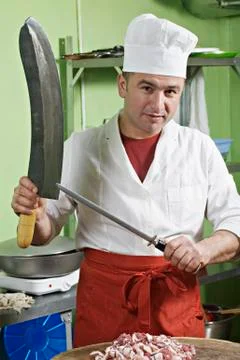 A chef sharpening a large knife 스톡 사진