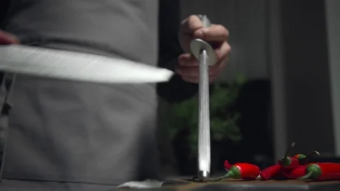 Chef sharpens the knife at the kitchen, preparations for food cooking, kitchen Stock Footage 77193110