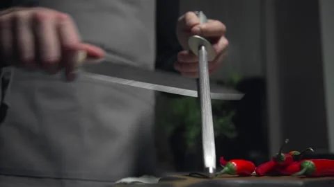 Chef sharpens knife preparations for cooking food Stock Footage 143779442