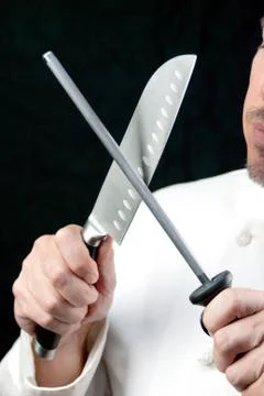Chef sharpens knife, side Stock Photos