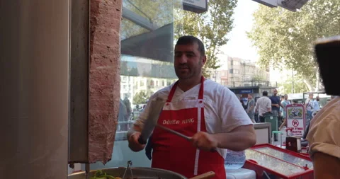 Chef sharpens long knife. Cook on street in front of electric grill sharpens Stock Footage 231717215