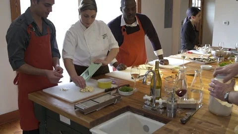 Chef showing a student how to grate garlic Stock Footage 77081725