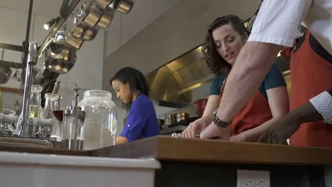 Chef showing a student how to use a dough roller Stock Footage 77081749