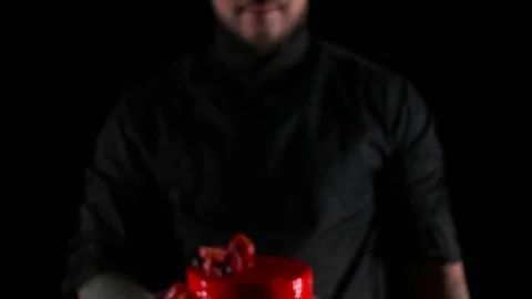 Chef shows dessert on a black background Stock Footage 69920358