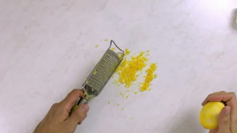 Chef shredding lemon with grater. Making Lemon Mascarpone Pie Series. Stock Footage 98808734