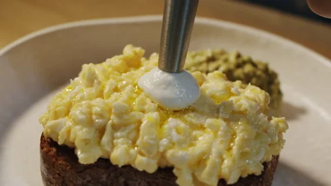 The chef with siphon adds Parmesan mousse on top of the eggs toast Video stock 152650580