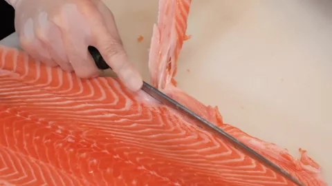 Chef Skillfully Cuts Salmon Meat from Skin for Sushi and Sashimi Preparation Stock Footage 333489142