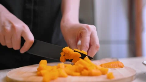 Chef skillfully cuts yellow peppers into strips on wooden surface Stock Footage 329062738