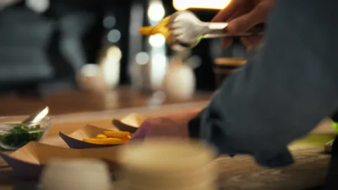 Chef skillfully prepares garnishes during a busy culinary event in a modern Stock Footage 323729629