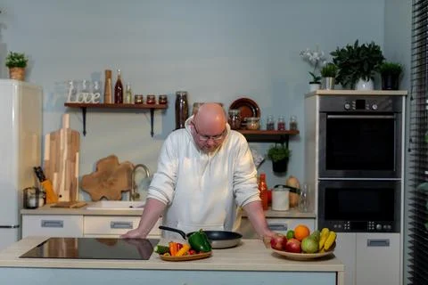 The chef is skillfully preparing vibrant ingredients in a modern kitchen Stock Photos