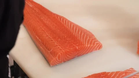 Chef Skillfully Slicing a Fresh Raw Salmon Fillet on a Cutting Board Stock Footage 333489254