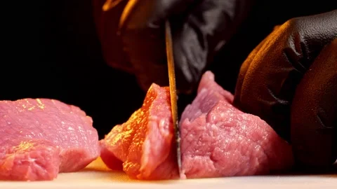 Chef slice a piece of raw beef. Close-up shot of meat slicing Stock Footage 147987360