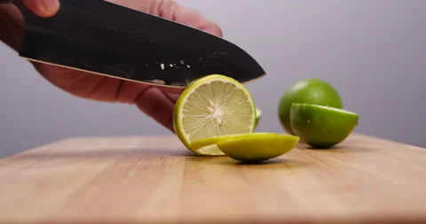 Chef sliced green lime with knife on wood cutting board table Stock-Footage 137989260
