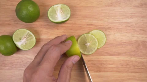 Chef sliced green lime with knife on wood cutting board table Stock Footage 138288673