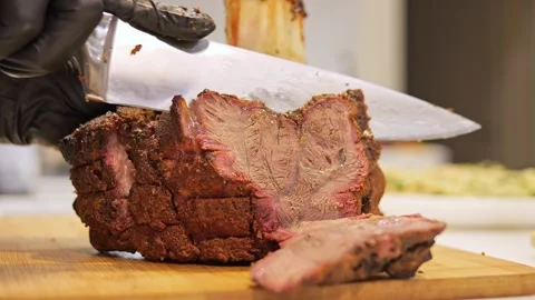 Chef slices barbecue meat, showcasing expert knife skills and juicy tender meat Stock Footage 275887694