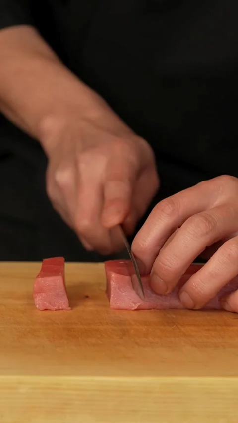 Chef slices a block of tuna on a board Stock Footage 331770323