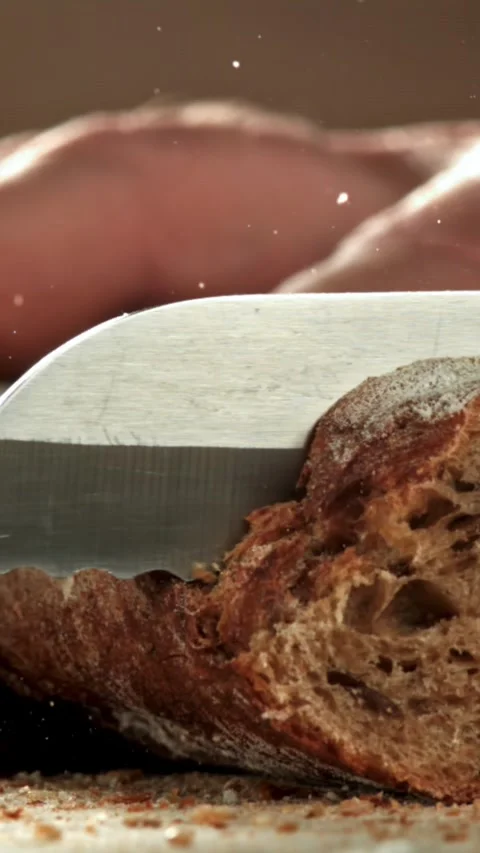 The chef slices bread. Fresh baguette sliced. Filmed on a high-speed camera at Stock Footage 335370565