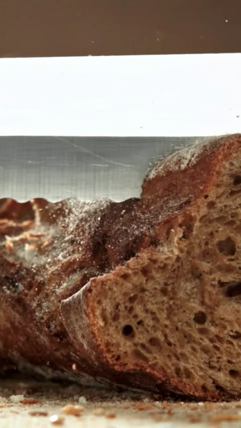 The chef slices bread. Fresh baguette sliced. Filmed on a high-speed camera at Stock Footage 335370837