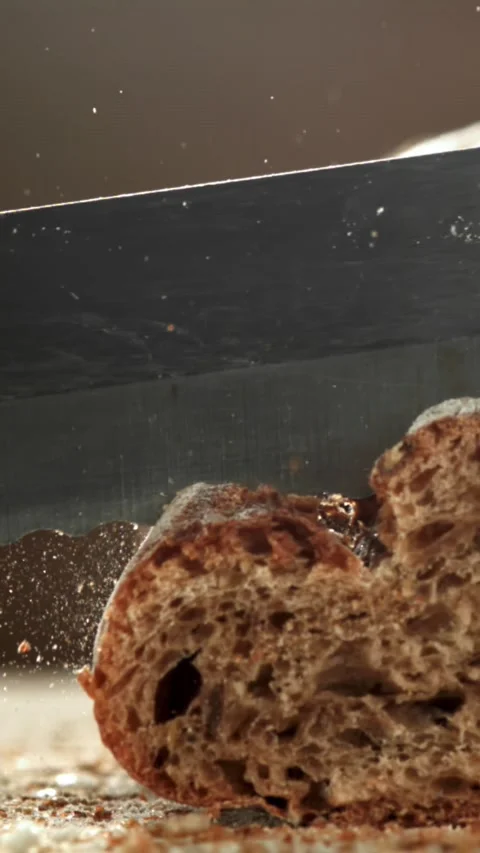 The chef slices bread. Fresh baguette sliced. Filmed on a high-speed camera at Stock Footage 335377720