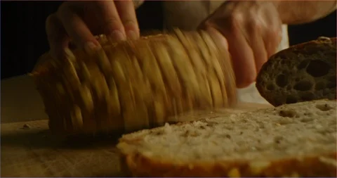 Chef slices brown bread with cereals macro shot Stock Footage 126295792