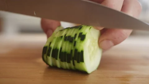 Chef slices a bunch of cucumber during meal prep 스톡 동영상 153289977