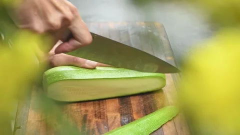 The chef slices courgette on a cutting board. Stock-Footage 169800090