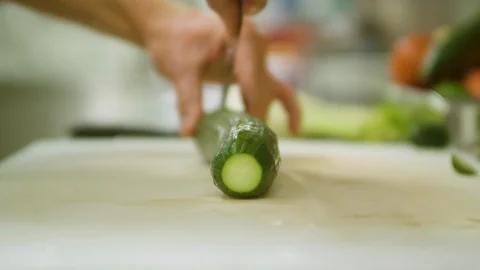 Chef slices cucumber on cutting board Stock Footage 104664296