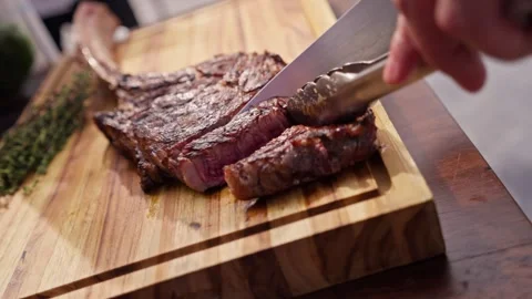 Chef Slices Cuts Large Bone-in Ribeye Tomahawk Steak On Fire Grill Stock Footage 288038775
