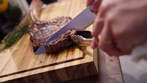 Chef Slices Cuts Large Bone-in Ribeye Tomahawk Steak On Fire Grill Stock Footage 288038777