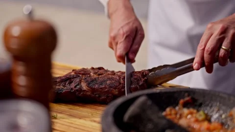 Chef Slices Cuts Large Bone-in Ribeye Tomahawk Steak On Fire Grill Stock Footage 288038783