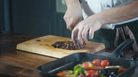 Chef slices finished steak on a cutting board in a restaurant. Stock Footage 124712701