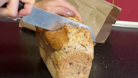 Chef slices fresh bread. Filmed on a high-speed camera Slices of whole wheat Stock Footage 326470535