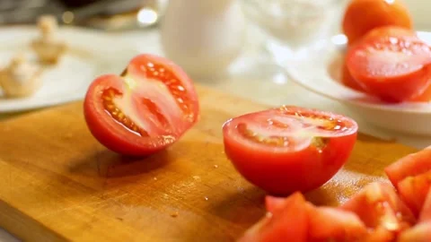 Chef slices a fresh red tomato on wooden board Stock Footage 333831032
