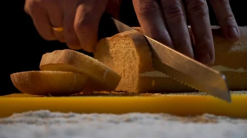 Chef slices freshly baked bread in the kitchen. Bread of own production.Close up Stock Footage 121312828