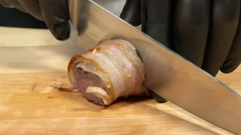 Chef slices fried meat wrapped in bacon Video stock 306803960