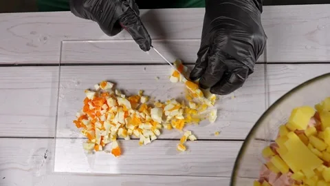The chef slices hard-boiled eggs for the olivier salad. High quality 4k footage Vidéo 291683328