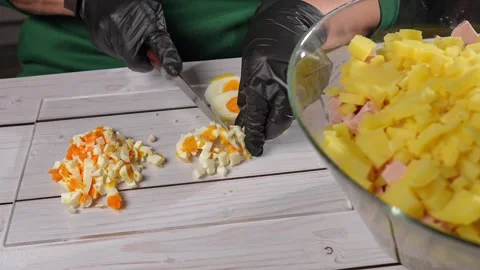 The chef slices hard-boiled eggs for the olivier salad. High quality 4k footage Vidéo 291684581