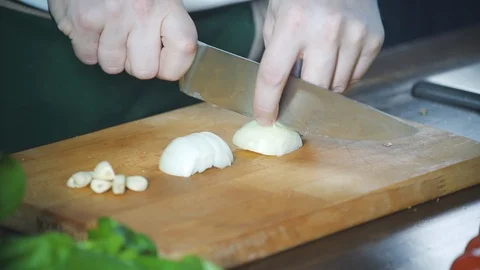 Chef slices onion on a cutting board in a restaurant. Prepare food. Vidéo 124752823