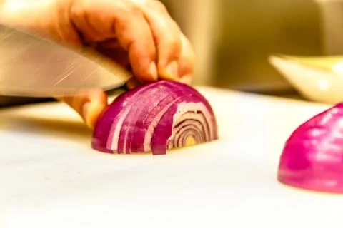 Chef slices red onion Stock Photos
