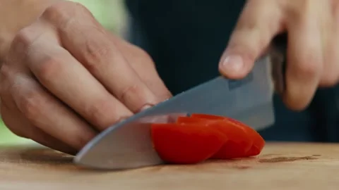 Chef slices tomato into salad close up of hands and knife full HD video Stock Footage 130778155